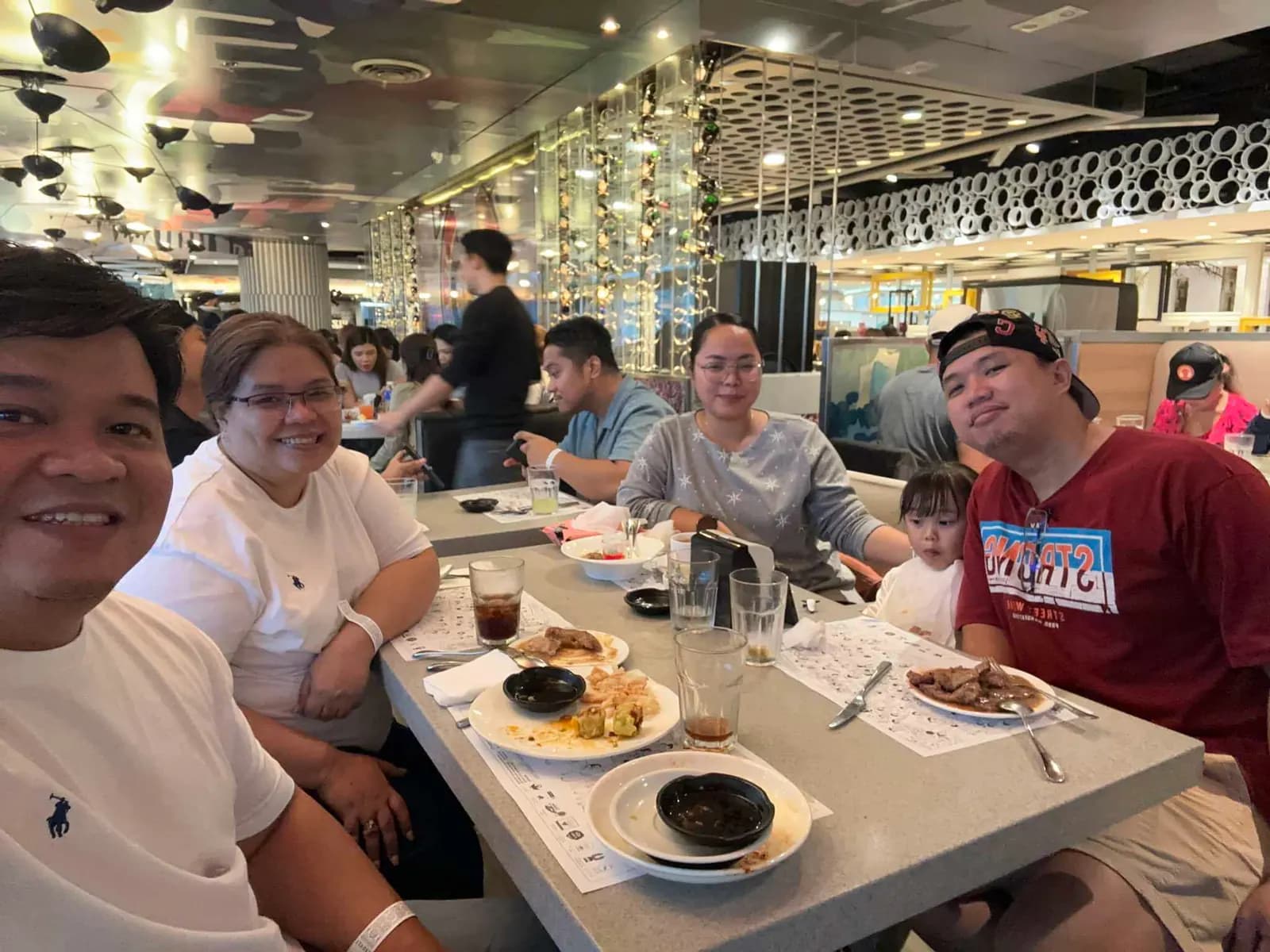 BrokerVA teammates sharing a meal along a long table at the bowling and lunch buffet outing