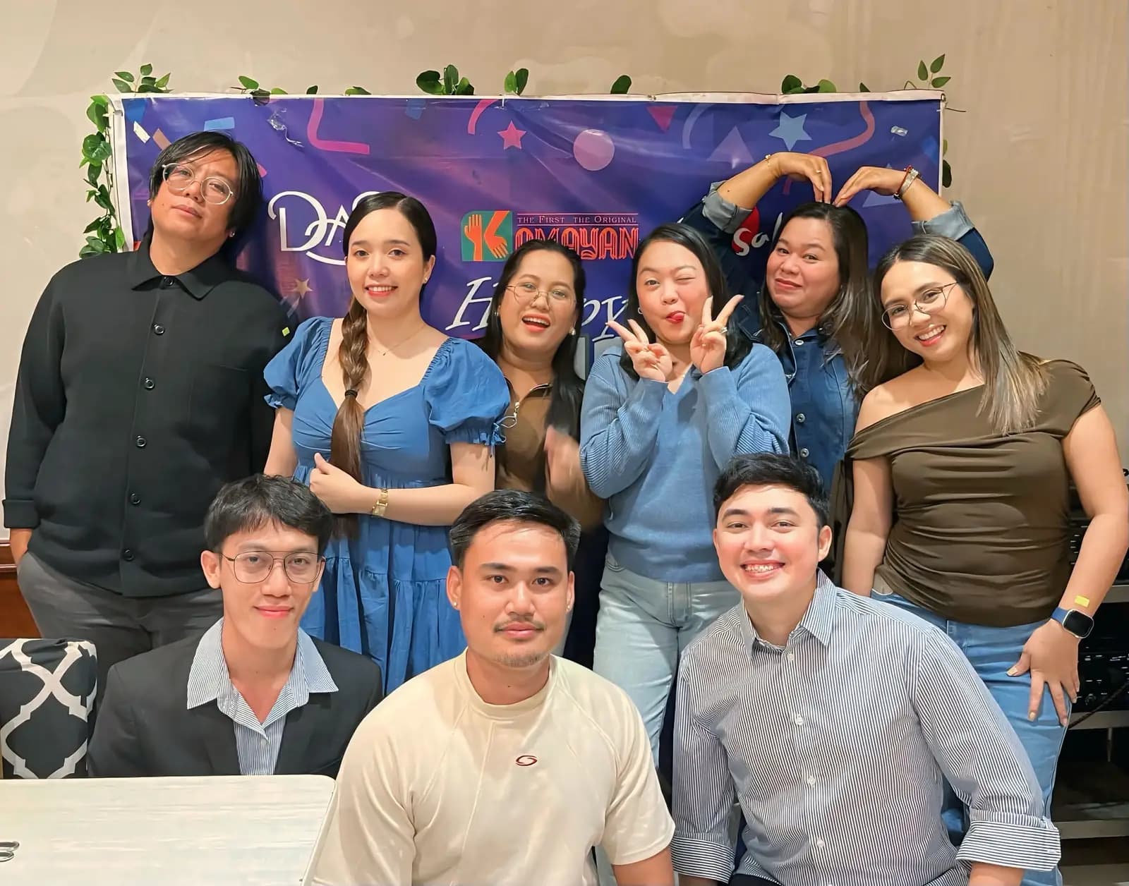 Teammates posing at the decorated photo backdrop during the July 2026 quarterly gathering