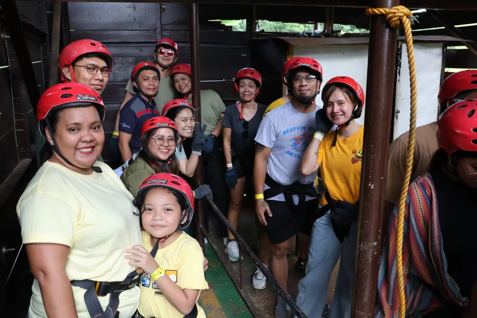 Teammates in red safety helmets before taking on the obstacle course, June 2025 team building