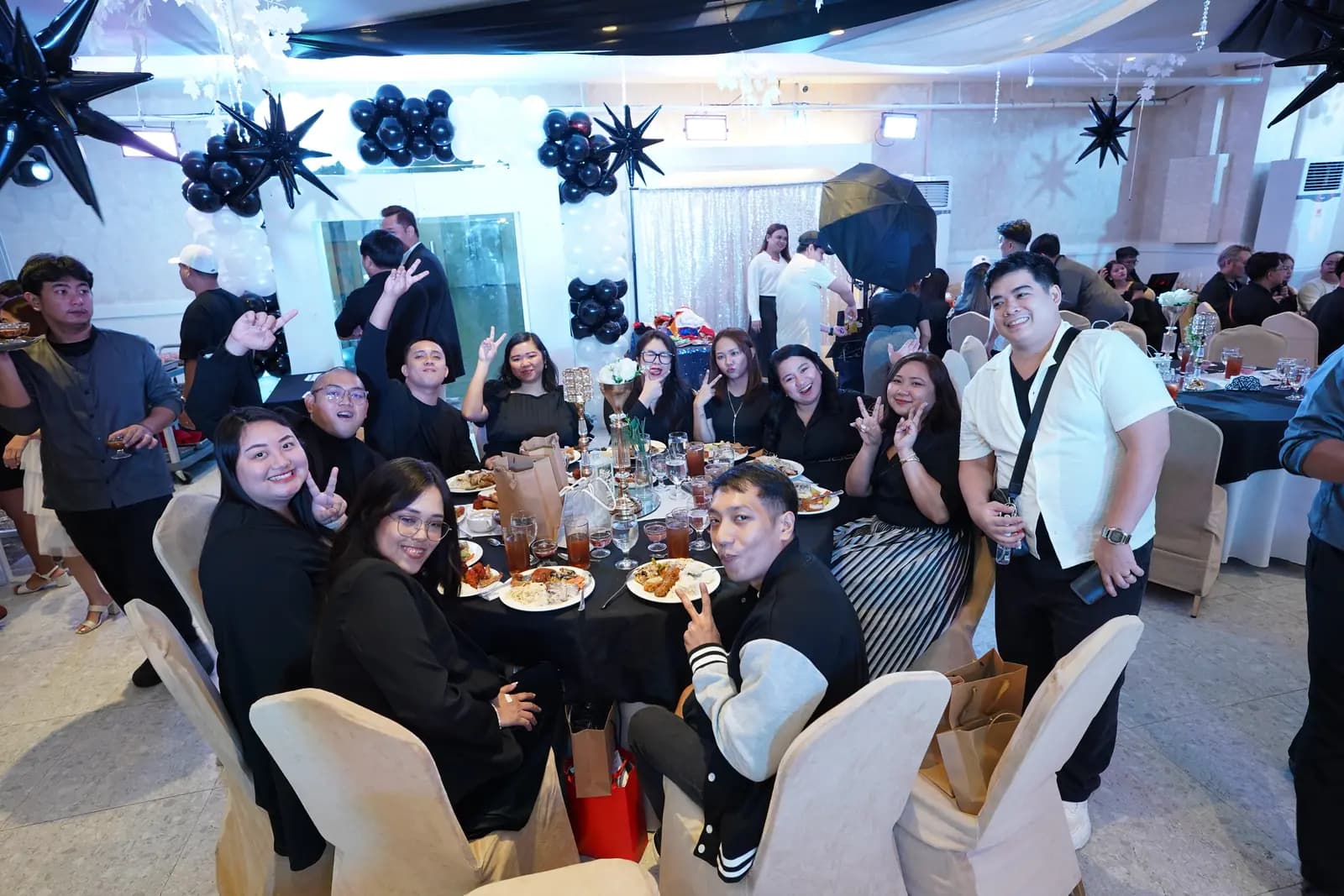 Teammates posing between the banquet tables at the 2025 year-end party
